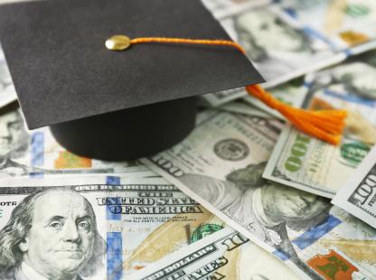 Photo of graduation cap with currency in the background