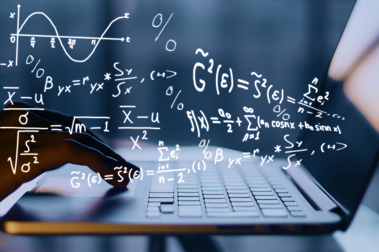 Mathematical equations floating over a student's laptop