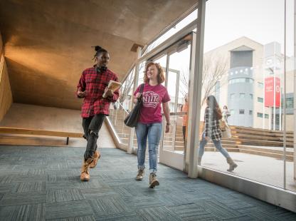 Male and female student walking in a hallway