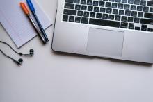 Laptop on desk with pens and headphones